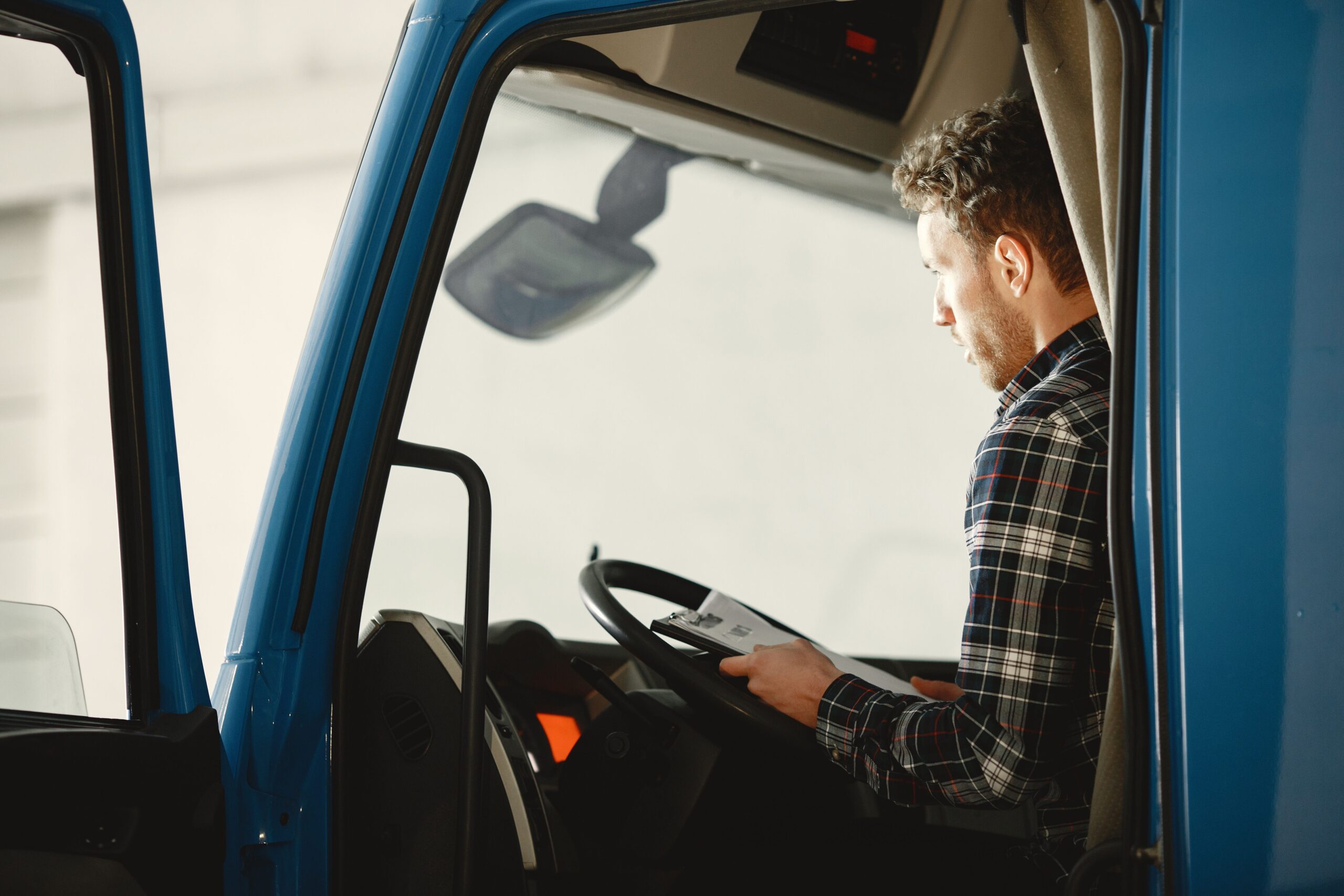 A male truck driver in the driver's seat, symbolizing the job and salary expectations for truck drivers.