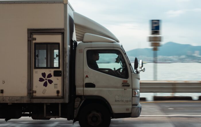 A white truck driving on a road, illustrating vehicles permissible under a standard car license.